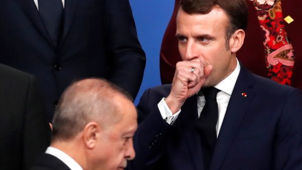 In this file photo taken on December 4, 2019 France's President Emmanuel Macron (R) gestures as Turkey's President Recep Tayyip Erdogan walks past him during a family photo as part of the NATO summit at the Grove hotel in Watford, northeast of London. Turkish President Recep Tayyip Erdogan slammed on October 24, 2020 his French counterpart, Emmanuel Macron, over his policies toward Muslims, saying that he needed "mental checks." "What can one say about a head of state who treats millions of members from dif