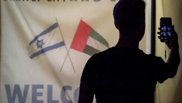 A member of an Israeli tech delegation uses his phone in a video call during an evening meeting with Emirati counterparts at a hotel in Dubai on October 25, 2020. (AFP)