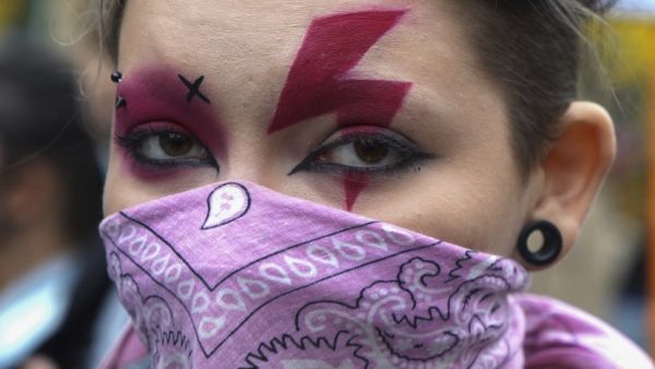 A woman sports a lightning bolt painted over her eyes as she attends a demonstration against the tightening of Poland's already restrictive abortion law on October 28, 2020 in Warsaw. Women in Poland walked off the job and hit the streets nationwide on October 28, 2020, the seventh straight day of mass protests over a court ruling to impose a near-total abortion ban in Poland. JANEK SKARZYNSKI / AFP