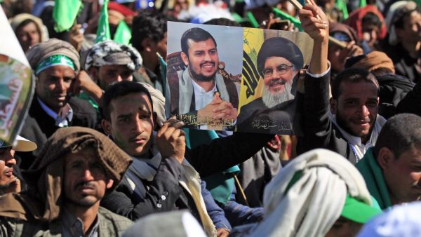 A Yemeni man holds up pictures of Huthi rebel leader Abdul-Malik al-Huthi (L) and chief of the Shiite Muslim movement Hezbollah Hassan Nasrallah during a ceremony marking the birth anniversary of Islam's Prophet Mohammad, known in Arabic as "Mawlid al-Nabawi", in the Yemeni capital Sanaa on October 29, 2020. Mohammed HUWAIS / AFP