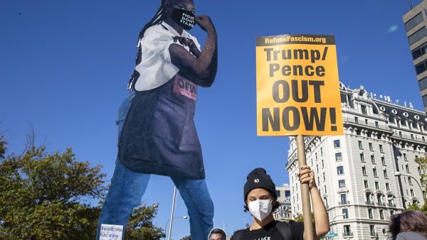 Protesters hold up a cardboard cutout during the Women’s March at Freedom Plaza on October 17, 2020 in Washington, DC. (AFP)
