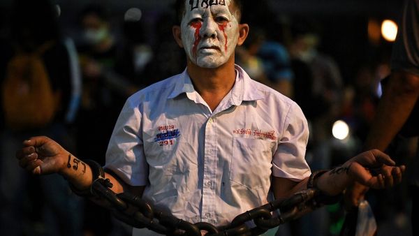 A pro-democracy protester wears chains and make-up during a demonstration at a road intersection in Bangkok today, after Thailand issued an emergency decree following an anti-government rally the previous day. (AFP/File)