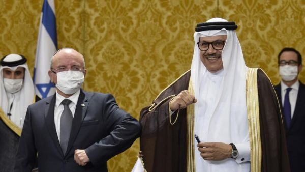 Bahraini Foreign Minister Abdullatif bin Rashid al-Zayani, right, and Israeli National Security Adviser Meir Ben Shabbat bump elbows after signing ceremony in Manama on 18 October (AFP/File photo)