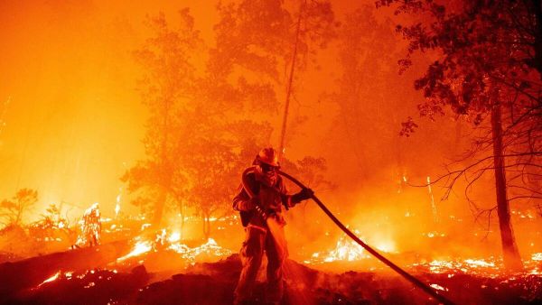 A firefighter douses flames as they push towards homes during the Creek fire in the Cascadel Woods area of unincorporated Madera County, California on September 7, 2020. (AFP/File Photo)