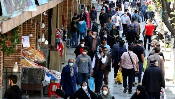 Iranians, some wearing protective gear amid the COVID-19 pandemic, shop on a street by the Grand Bazaar market in the capital Tehran, on April 18, 2020 (ATTA KENARE / AFP)