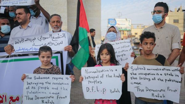 Palestinian demonstrators lift placards protesting the Sudan normalisation agreement with Israel, in Rafah town in the southern Gaza Strip on October 24, 2020. Sudan and Israel agreed on October 23 to normalise relations, in a US-brokered deal to end decades of hostility that was widely welcomed but stirred Palestinian anger. SAID KHATIB / AFP
