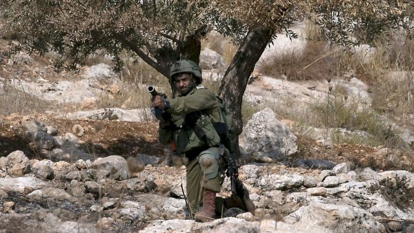 An Israeli soldier aims his tear gas launcher during clashes with Palestinian protesters following a demonstration against the expansion of settlements, near the village of Beit Dajan, east of Nablus, on October 30, 2020. JAAFAR ASHTIYEH / AFP