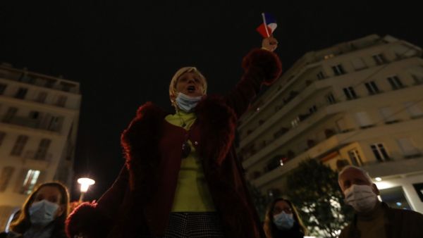 A woman sings the "Marseillaise", the French national anthem, outside Notre-Dame de l'Assomption Basilica in Nice on October 31, 2020, to pay tribute to the victims two days after a knife attacker killed three people, cutting the throat of two, inside the church of the French Riviera city. Valery HACHE / AFP