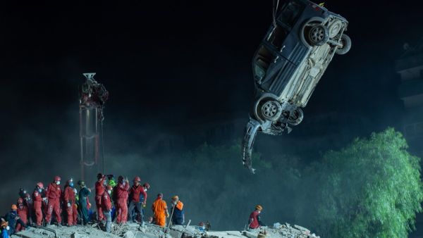 A crane lifhts the wreckage of a car as rescue workers search for survivors in the debris of a collapsed building on November 1, 2020 in the Bayrakli district of Izmir, after a powerful earthquake struck Turkey's western coast and parts of Greece. AFP