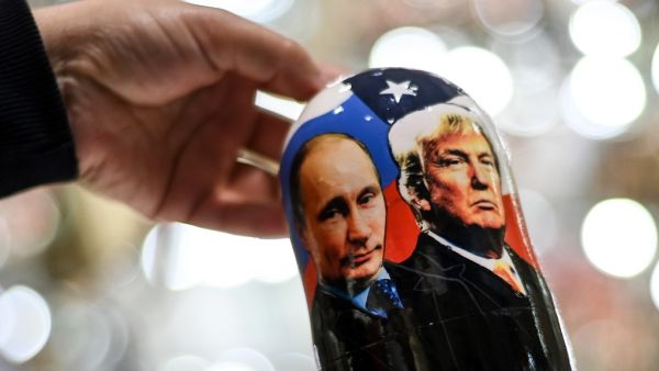 A vendor shows a traditional Russian wooden nesting doll, Matryoshka doll, depicting Russia's President Vladimir Putin and US President and Republican presidential nominee Donald Trump at a gift shop in central Moscow on November 3, 2020. Kirill KUDRYAVTSEV / AFP