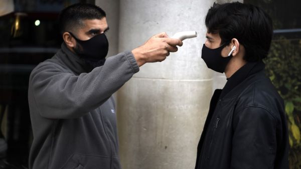 A shopper has his temperature taken at the entrance to the Apple store in Regent Street, central London on November 3, 2020, as the country prepares for a second national lockdown during the novel coronavirus COVID-19 pandemic. Britain's Prime Minister Boris Johnson announced at the weekend that a new nationwide lockdown would come into force from Thursday and end on December 2, bringing England into line with other parts of the UK and Europe. While many shoppers said they supported the measures, others sai