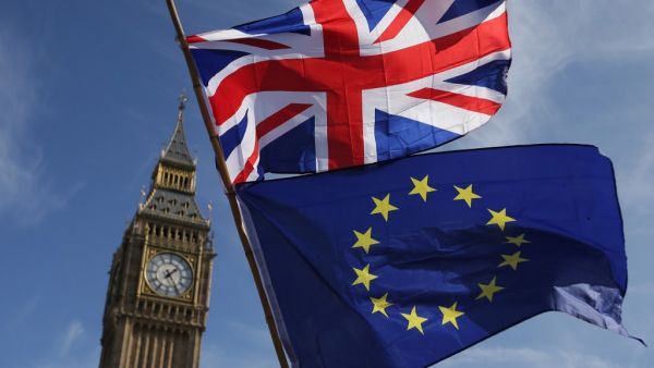  In this file picture taken on March 25, 2017 an EU flag and a Union flag held by a demonstrator is seen with Elizabeth Tower (Big Ben) and the Houses of Parliament as marchers taking part in an anti-Brexit, pro-European Union (EU) enter Parliament Square in central London, ahead of the British government's planned triggering of Article 50 next week. Daniel LEAL-OLIVAS / AFP