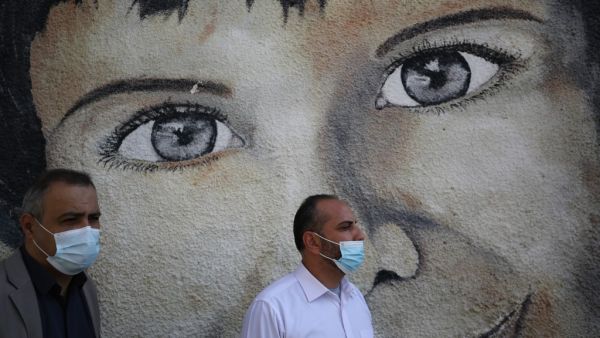 Palestinian UNRWA emplyees, mask-clad due to the COVID-19 coronavirus pandemic, protest outside the headquarters of the United Nations Relief and Works Agency for Palestine Refugees in the Near East (UNRWA) in Gaza City on November 17, 2020 against the reduction of their salaries.  AFP
