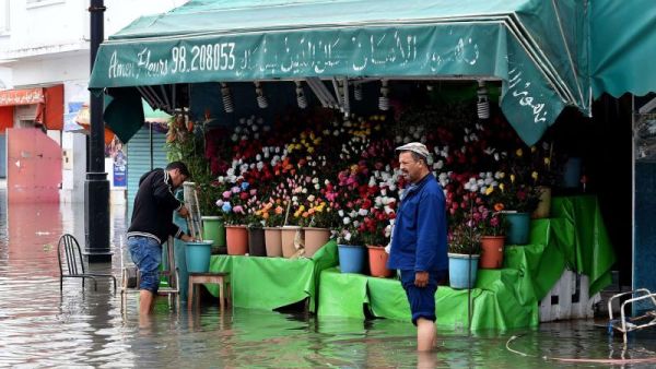A file picture shows a flower shop owner stranded in a street flooded by torrential rains in the Tunisian capital Tunis. (AFP)
