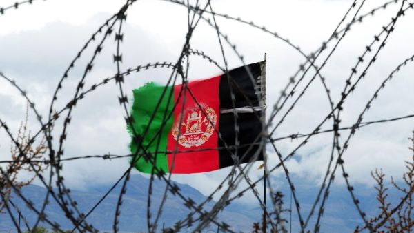 Afghan flag behind barbed wire. (AFP)