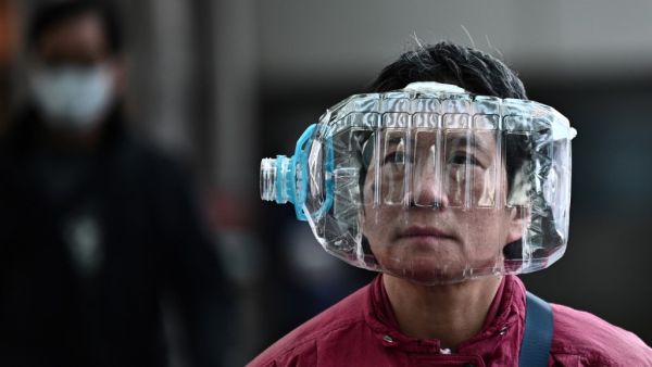 A woman wears a plastic water bottle with a cutout to cover her face, as she walks on a footbridge in Hong Kong on January 31, 2020, as a preventative measure following a virus outbreak which began in the Chinese city of Wuhan. The World Health Organization, which initially downplayed the severity of a disease that has now killed 170 nationwide, warned all governments to be "on alert" as it weighed whether to declare a global health emergency. Anthony WALLACE / AFP A woman wears a plastic water bottle with a cutout to cover her face, as she walks on a footbridge in Hong Kong on January 31, 2020, as a preventative measure following a virus outbreak which began in the Chinese city of Wuhan. The World Health Organization, which initially downplayed the severity of a disease that has now killed 170 nationwide, warned all governments to be "on alert" as it weighed whether to declare a global health emergency. Anthony WALLACE / AFP