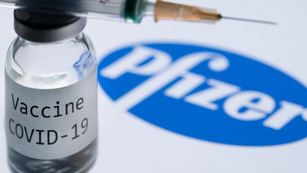 In this file photo taken on November 23, 2020 This illustration picture taken in Paris on November 23, 2020 shows a syringe and a bottle reading "Covid-19 Vaccine" next to the Pfizer company logo. Britain on December 2, 2020 became the first country to approve Pfizer-BioNTech's Covid-19 vaccine for general use and said it would be introduced next week. JOEL SAGET / AFP