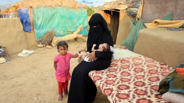 A woman carries a young infant suffering from severe malnutrition since birth in Yemen's northern Hajjah province on December 6, 2020. ESSA AHMED / AFP