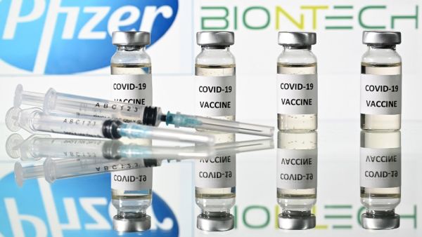 This file illustration photo taken on November 17, 2020 shows vials with Covid-19 Vaccine stickers attached and syringes with the logo of US pharmaceutical company Pfizer and German partner BioNTech. The US Food and Drug Adminstration on December 11, 2020 granted the Pfizer-BioNTech Covid-19 vaccine an emergency use authorization, paving the way for its imminent rollout across the country. JUSTIN TALLIS / AFP