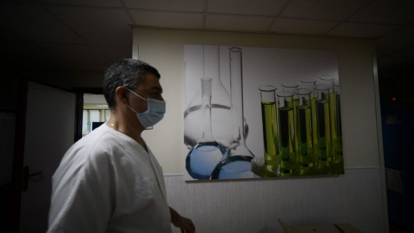 A medical worker wearing a face mask walks across the lab department of the Tor Vergata hospital in Rome on December 21, 2020, during the COVID-19 pandemic caused by the novel coronavirus. Filippo MONTEFORTE / AFP