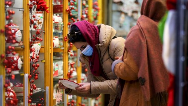 An Iranian woman, wearing a protective face mask, shops at a store selling Christmas decorations in the capital Tehran on December 22, 2020. ATTA KENARE / AFP