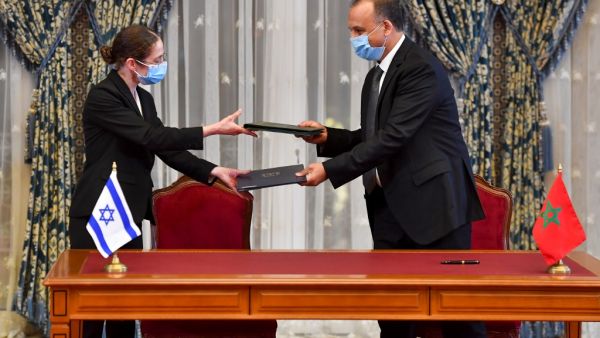 Chief economist at Israel's Ministry of Finance Shira Greenberg (L) and Morocco's Director General Of the Customs and Indirect Tax Administration at the Ministry of Economy and Finance Nabil Lakhdar exchange a signed agreement at the Royal Palace in the Moroccan capital Rabat on December 22, 2020, on the first Israel-Morocco direct commercial flight, marking the latest US-brokered diplomatic normalisation deal between the Jewish state and an Arab country.  FADEL SENNA / AFP