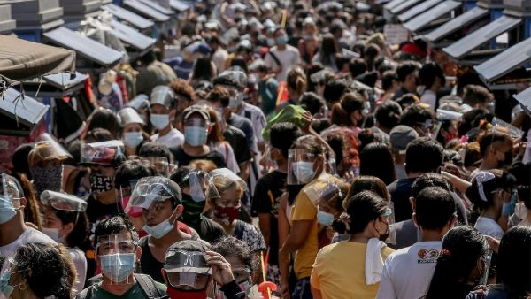 People wearing face shields and masks amid the Covid-19 coronavirus pandemic visit a popular shopping market hours before Christmas eve in Manila on December 24, 2020. STR / AFP