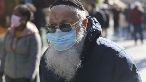 An ultra-Orthodox Jewish man walks clad in face mask along the Mahane Yehuda market in Jerusalem on December 27, 2020, before the start of a third lockdown due to the COVID-19 coronavirus pandemic. Israel is set to begin its third lockdown, as Prime Minister Benjamin Netanyahu voices optimism that a "world record" vaccination drive will restore a degree of normality within weeks. MENAHEM KAHANA / AFP