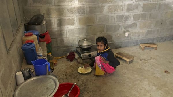 A child of Rohingya refugee eats food inside the room of a housing complex at the Bhashan Char island after they were relocated in Noakhali on December 30, 2020. Mohammad Al-MASUM MOLLA / AFP