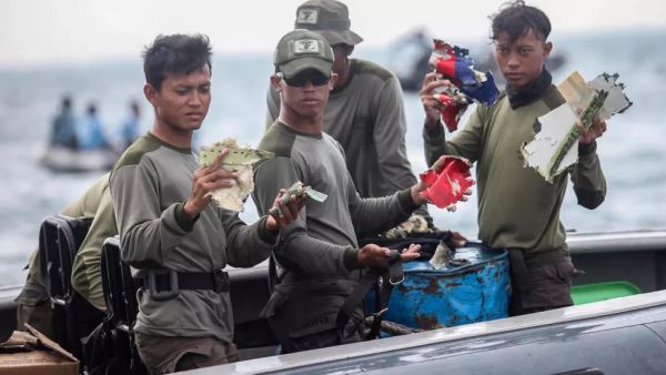 غطاسون من البحرية الاندونيسية يعرضون قطعا من حطام طائرة البوينغ