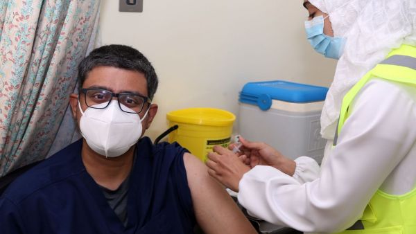 A doctor receives his first dose of the Pfizer-BioNTech COVID-19 vaccine in the Omani capital Muscat on December 27, 2020. MOHAMMED MAHJOUB / AFP