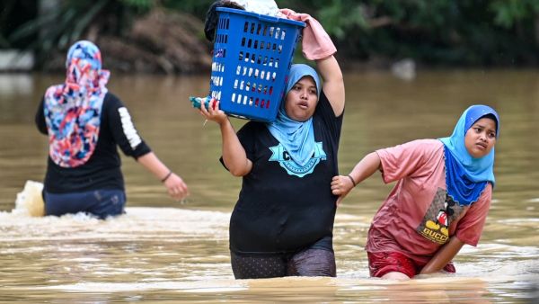 Residents carry their belongings through floodwaters in Kuala Kaung, near Lanchang in Malaysia's Pahang state on January 4, 2021. Mohd RASFAN / AFP