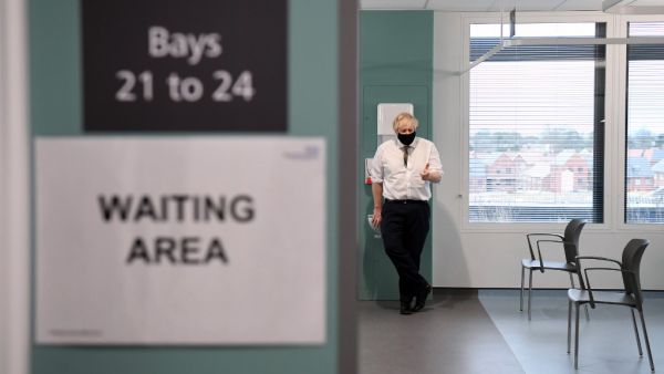 Britain's Prime Minister Boris Johnson speaks to NHS staff (unseen) waiting to receive a dose of the AstraZeneca/Oxford Covid-19 vaccine during a visit to Chase Farm Hospital in north London on January 4, 2021, the day that Britain's NHS (National Health Service) ramps up its vaccination programme with the rollout of the newly approved AstraZeneca/Oxford COVID-19 vaccine jab. AFP/File