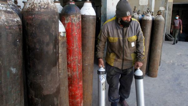 A worker carries oxygen canisters to be used by hospitals treating COVID-19 patients, at a factory in the southern Lebanese city of Sidon (Saida), on January 9, 2021. Since the start of the Covid-19 pandemic, Lebanon has recorded nearly 200,000 cases including 1,537 deaths, according to health ministry figures. AFP
