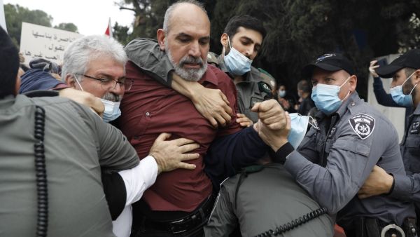 Israeli police detain a protester as Arab Israelis demonstrate on January 13, 2021 in the northern city of Nazareth against a plan by Prime Minister Benjamin Netanyahu to visit their city. Since July, thousands of Israelis have rallied each week to protest against the prime minister and the economic fallout from the pandemic. Ahmad GHARABLI / AFP