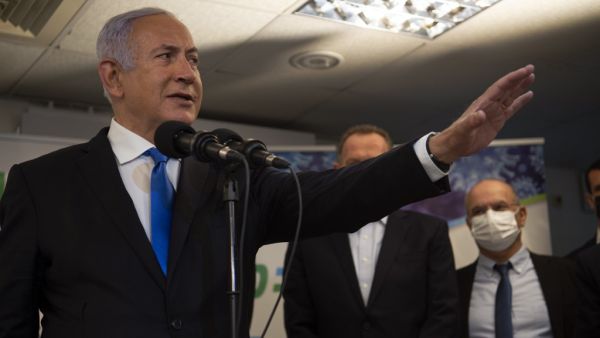 Israel's Prime Minister Benjamin Netanyahu visits the anti-coronavirus vaccination facility in the northern Israeli Arab city of Nazareth on January 13, 2021. A group of Arab Israelis demonstrated against Netanyahu's visit to the fascililty in their city. Since July, thousands of Israelis have rallied each week to protest against the prime minister and the economic fallout from the pandemic. Gil ELIYAHU / POOL / AFP