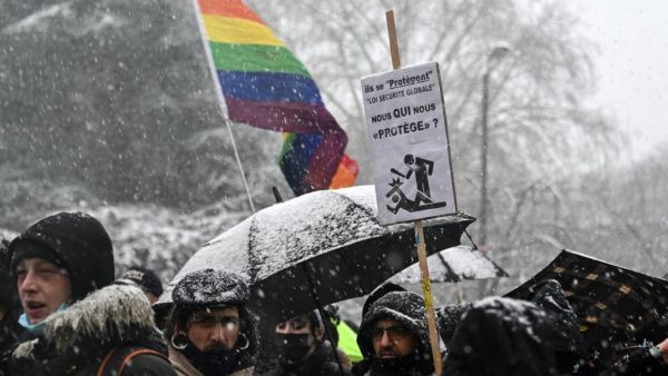A protester holds a placard during a so-called "march of freedoms" to protest against the 'global security' draft law that would restrict publication of pictures showing the faces of police officers on duty on January 16, 2021 in Lille. DENIS CHARLET / AFP