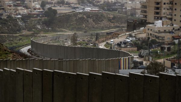 A picture taken on January 20, 2021 shows the Israeli settlement of Pisgat Zeev (L), built in a suburb of the mostly Arab east Jerusalem, and the Palestinian Shuafat refugee camp (R) behind Israel's controversial separation wall. AHMAD GHARABLI / AFP A picture taken on January 20, 2021 shows the Israeli settlement of Pisgat Zeev (L), built in a suburb of the mostly Arab east Jerusalem, and the Palestinian Shuafat refugee camp (R) behind Israel's controversial separation wall. AHMAD GHARABLI / AFP