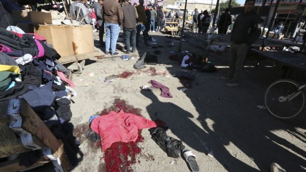 A picture shows the scene of a twin suicide bombing on a bustling commercial street in the heart of Baghdad on January 21, 2021. The toll in a twin suicide bombing in an open-air Baghdad market morning topped 20 dead and 40 wounded, an interior ministry official told AFP. The ministry said the first suicide bomber had rushed into the market and claimed to feel sick, so that people would gather around him. He then detonated his explosives. Sabah ARAR / AFP