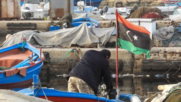 A man rummages through a boat moored at the port of Libya's capital Tripoli on January 24, 2021. Mahmud TURKIA / AFP