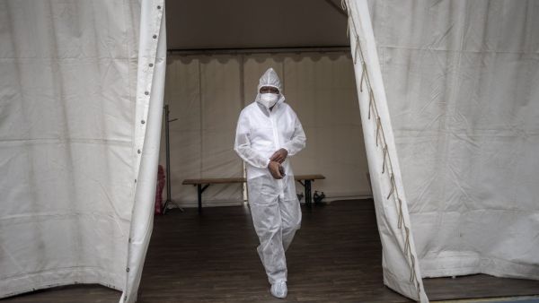 A healthcare worker wearing personal protective equipment (PPE) makes his way out of a temporary ward dedicated to the treatment of possible COVID-19 coronavirus patients at the Nasrec Field Hospital in Soweto, on January 25, 2021. Michele Spatari / AFP