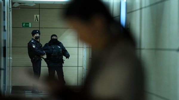 Police officers are seen in a hallway of a business centre, which houses the office of opposition leader Alexei Navalny's Anti-Corruption Foundation (FBK), in Moscow on January 27, 2021. Russian authorities on January 27 ramped up pressure on the opposition, searching the apartments and offices of jailed Kremlin critic Alexei Navalny ahead of new protests called for the weekend to demand his release. Ivan Zhdanov, the head of Navalny's FBK Anti-Corruption Foundation, said police were searching flats linked 