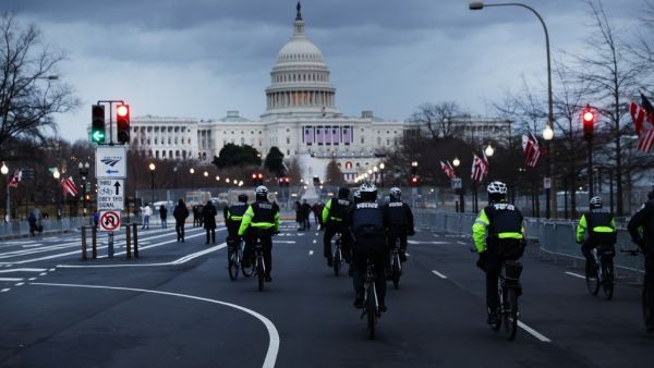 Police officers patrol a street leading to the U.S. Capitol on January 16, 2021 in Washington, DC. The National Guard is expected to deploy more than 20,000 troops in and around the Capitol and many area businesses will remain closed for the period leading up to the January 20th inauguration of Joseph Biden as president. SPENCER PLATT / GETTY IMAGES NORTH AMERICA / Getty Images via AFP