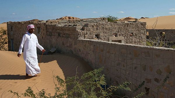 A former inhabitant of Wadi al-Murr, walks near an abandoned house in the Omani village, about 400 kms south-west of the capital Muscat. (AFP)