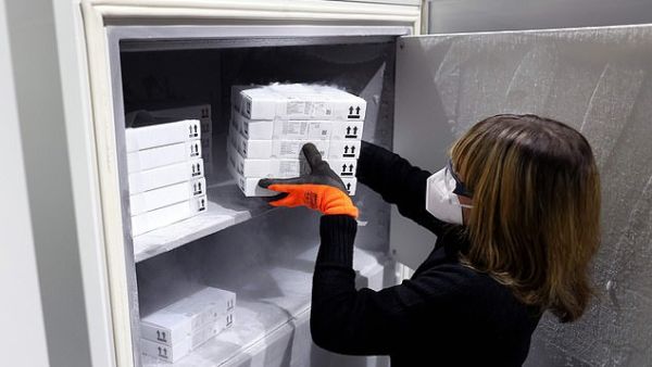 Jessica Mueller puts supplies of the Pfizer/BioNTech vaccine into an ultra-cold freezer at a warehouse near Magdeburg today, amid concern in Brussels over a separate bilateral deal between Berlin and the vaccine developers. AFP