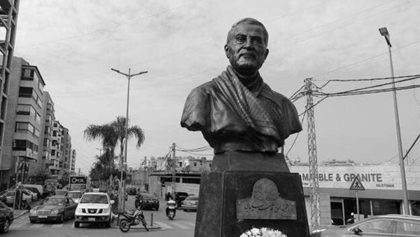 A photo taken on January 5, 2021 shows a Lebanese flag hanging on a building under construction behind the newly unveiled statue of Iran's most revered military commander, Qasem Soleimani, in the predominantly-Shiite Muslim Beirut southern suburb of Ghobeiry. Soleimani -- whom the US blamed for attacks on its interests in Iraq and elsewhere -- was killed in a US drone strike at Baghdad airport on January 3 last year, ratcheting up tensions between decades-old arch foes the United States and Iran. JOSEPH EID