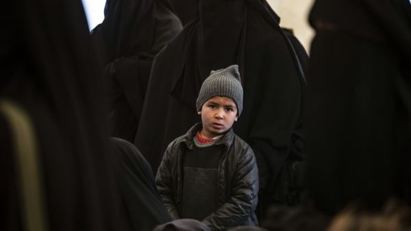 A boy sits among women awaiting departure during the release of another group of Syrian families from the Kurdish-run al-Hol camp which holds suspected relatives of Islamic State (IS) group fighters, in Hasakeh governorate in northeastern Syria, on January 28, 2021. Delil SOULEIMAN / AFP