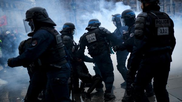 French riot police officers arrest a man during a demonstration against the "global security" draft law, that would restrict publication of pictures showing the faces of police officers on duty, in Paris on January 30, 2021. Christophe ARCHAMBAULT / AFP