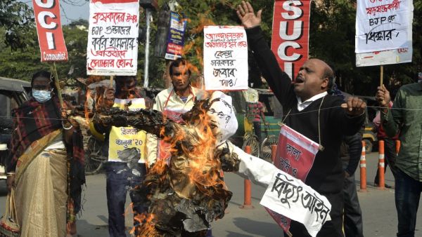 Activists and supporters of the Socialist Unity Centre of India (SUCI) shout slogans as they burn an effigy of Indian Prime Minister Narendra Modi during a protest rally supporting the ongoing farmers' protest against the central government's recent agricultural reforms, in Siliguri on January 31, 2021. DIPTENDU DUTTA / AFP