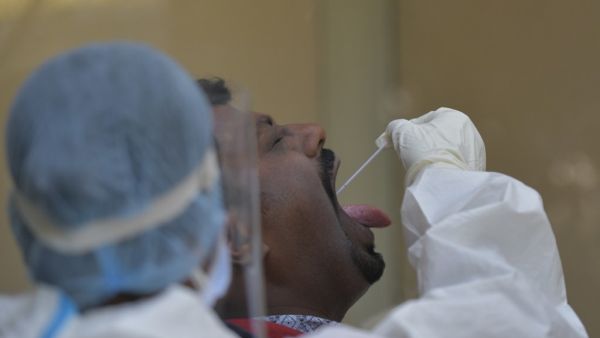 A health worker collects a swab sample from a man to test for the Covid-19 coronavirus at the KC General Hospital in Bangalore on February 1, 2021. Manjunath KIRAN / AFP